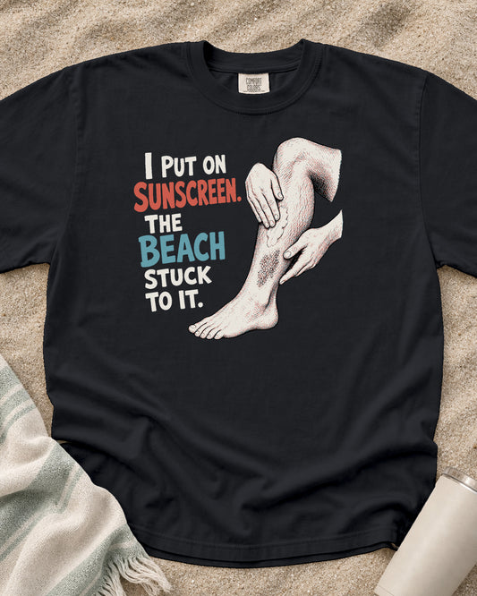 Graphite Comfort Colors 1717 tee with I Put on Sunscreen. The Beach Stuck to It graphic.