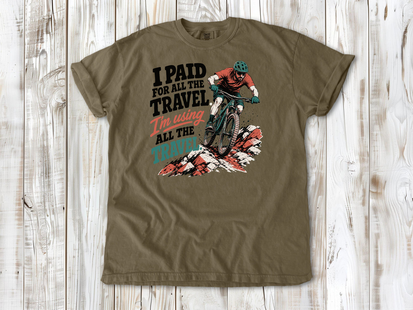 Graphite garment-dyed tee with I Paid for All the Travel mountain bike graphic.