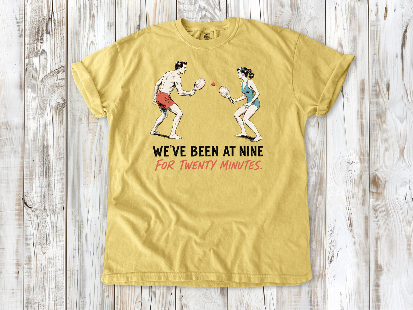 Grey garment-dyed tee with We've Been at Nine for Twenty Minutes beach paddleball graphic.
