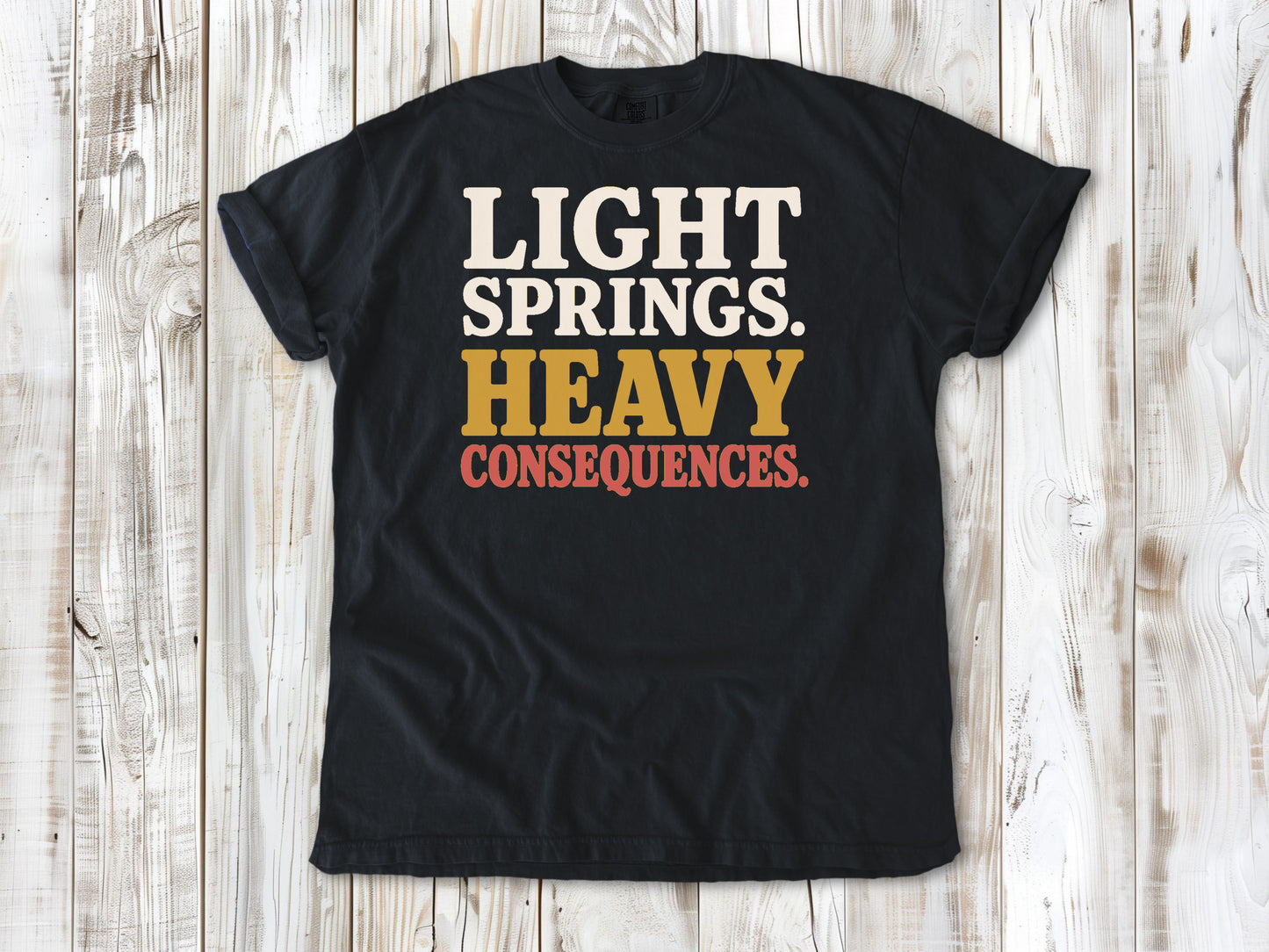 Graphite garment-dyed tee with Light Springs Heavy Consequences reformer Pilates graphic.