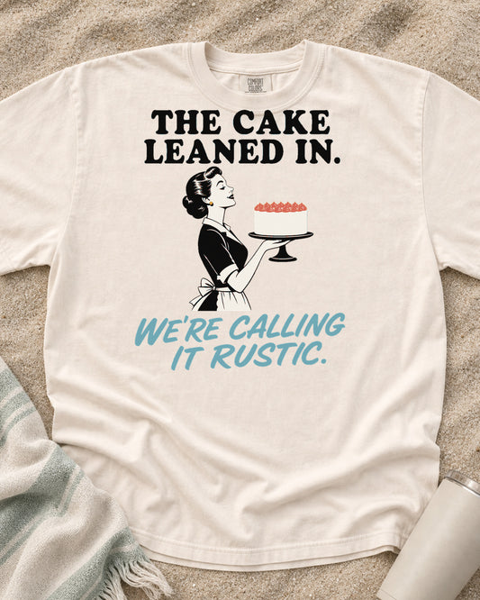 Ivory Comfort Colors 1717 tee with The Cake Leaned In. We're Calling It Rustic graphic.