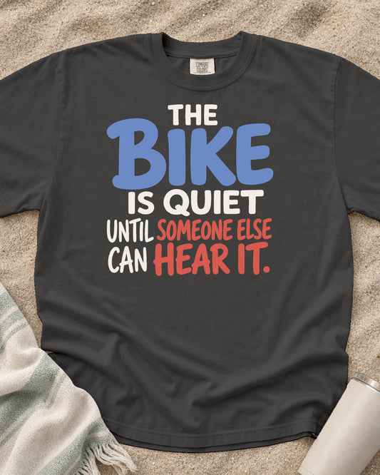 Pepper Comfort Colors 1717 tee with The Bike Is Quiet Until Someone Else Can Hear It graphic.