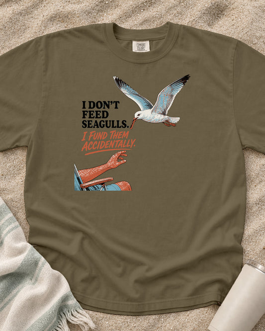 Khaki Comfort Colors 1717 tee with I Don't Feed Seagulls. I Fund Them Accidentally graphic.