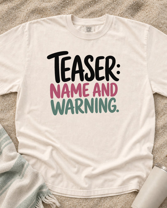 Ivory Comfort Colors 1717 tee with Teaser: Name and Warning graphic.