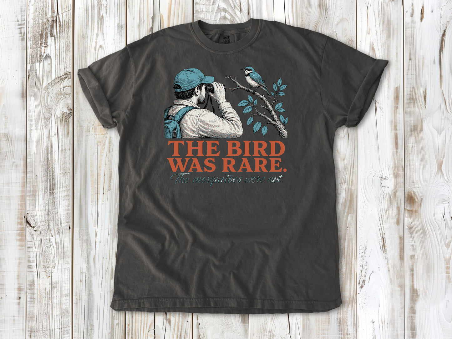 Ivory garment-dyed tee with The Bird Was Rare The Mosquitoes Were Not birdwatching graphic.