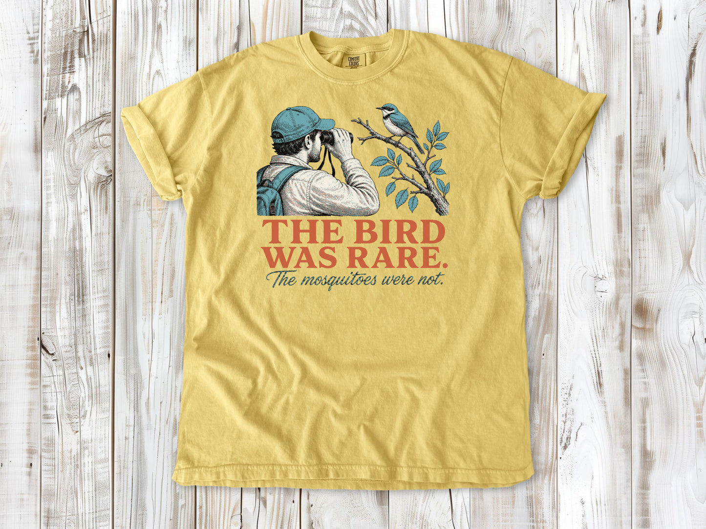 Grey garment-dyed tee with The Bird Was Rare The Mosquitoes Were Not birdwatching graphic.
