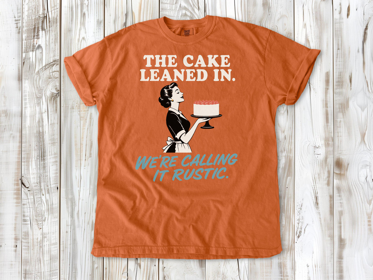Seafoam garment-dyed tee with The Cake Leaned In We're Calling It Rustic baking graphic.