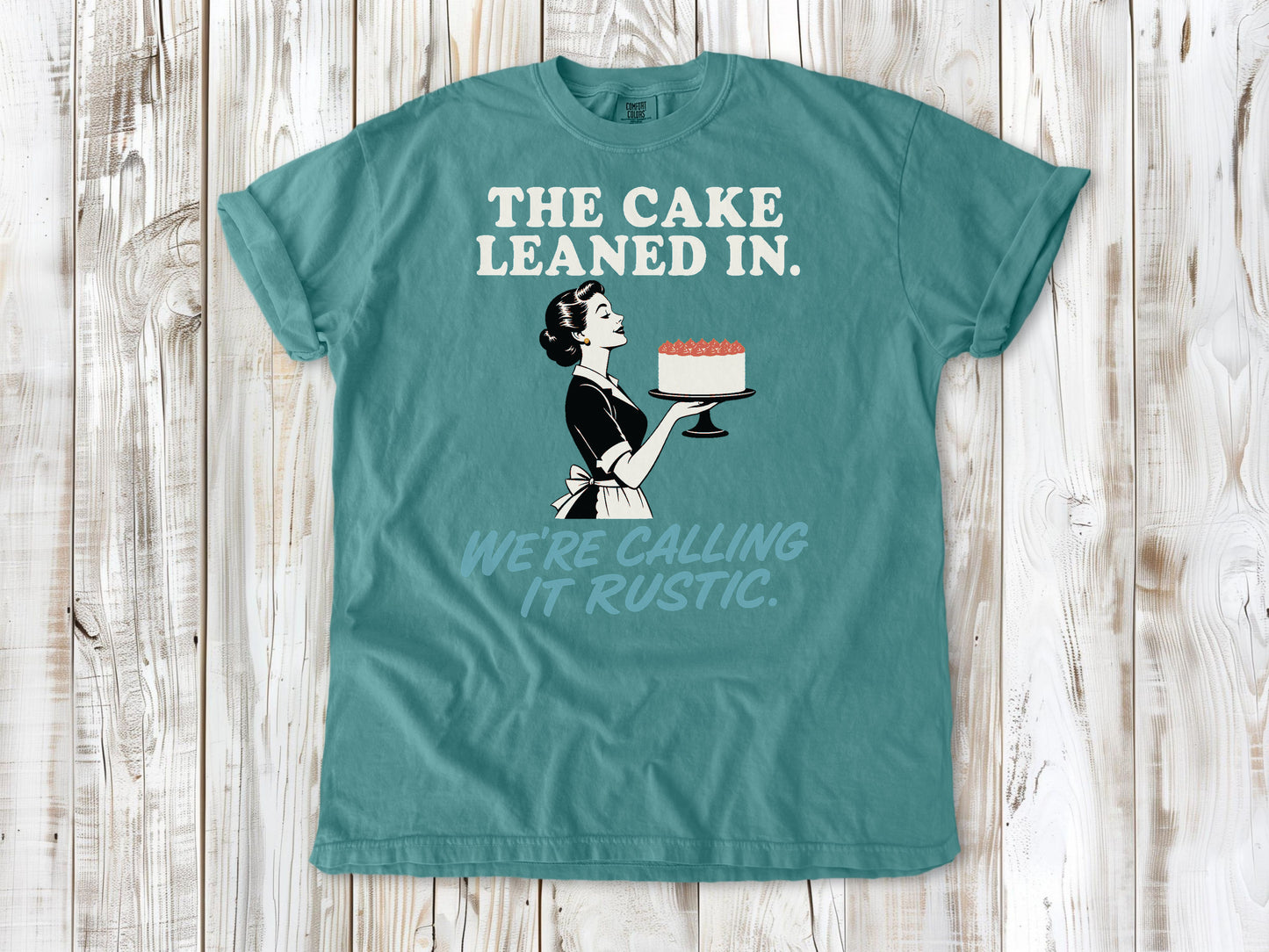 Mustard garment-dyed tee with The Cake Leaned In We're Calling It Rustic baking graphic.