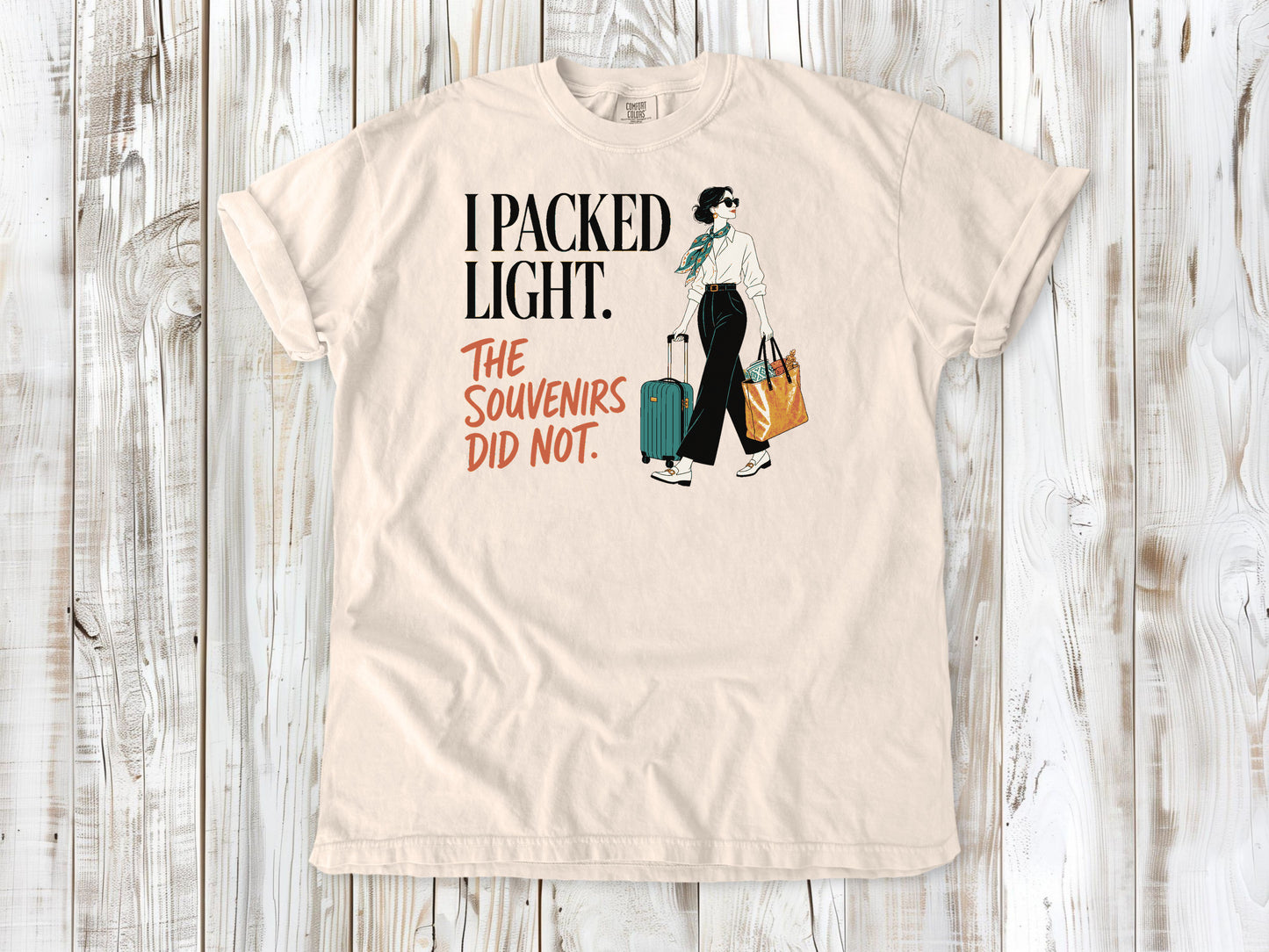 Butter garment-dyed tee with I Packed Light The Souvenirs Did Not travel graphic.