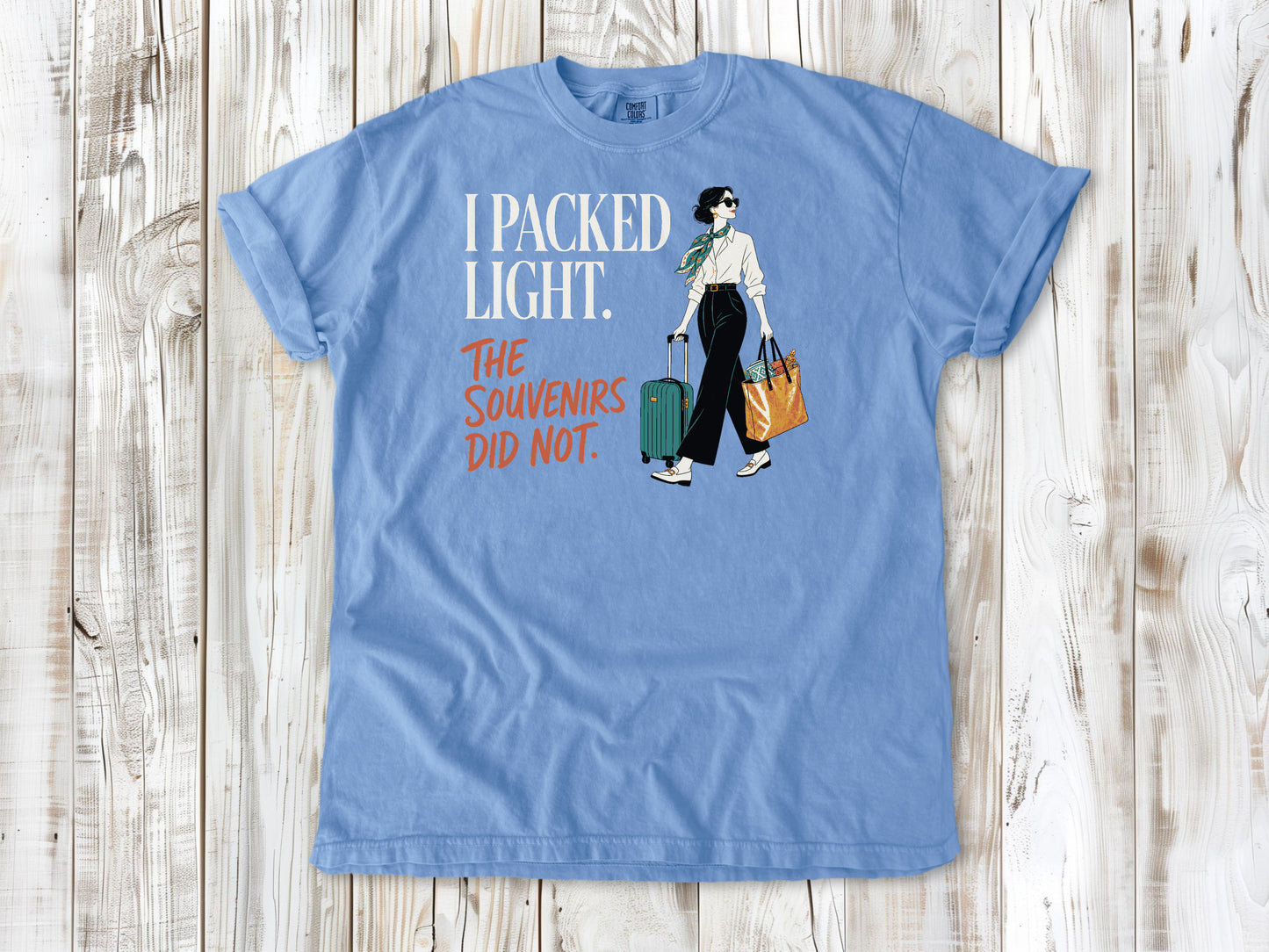 Pepper garment-dyed tee with I Packed Light The Souvenirs Did Not travel graphic.