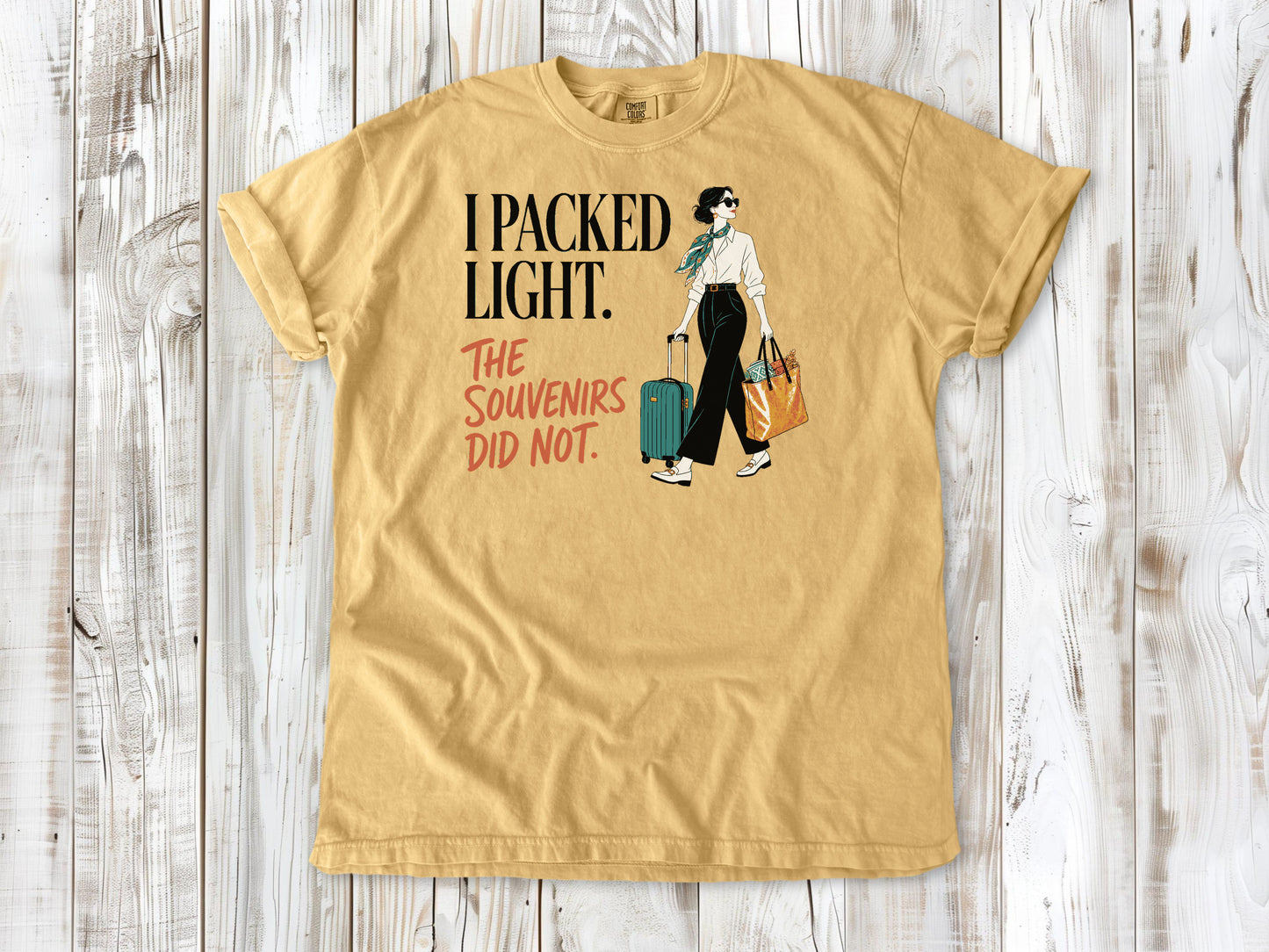 Burnt Orange garment-dyed tee with I Packed Light The Souvenirs Did Not travel graphic.