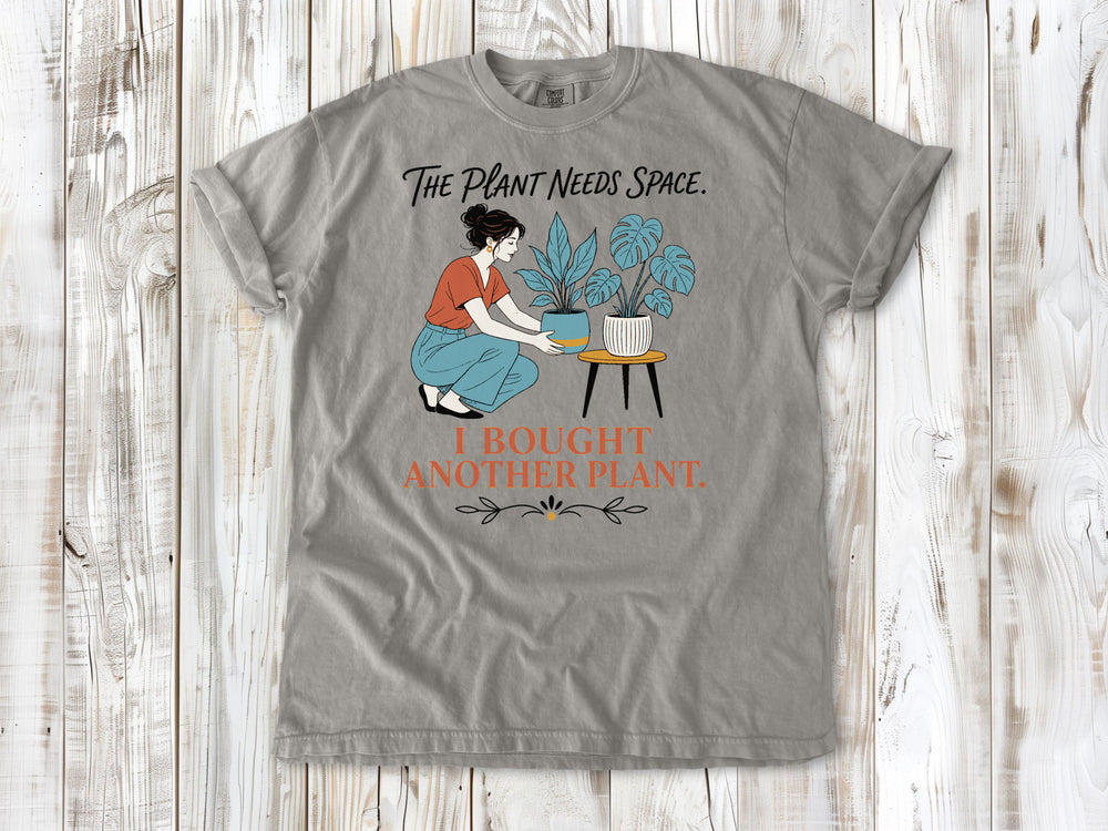 Khaki garment-dyed tee with The Plant Needs Space I Bought Another Plant houseplant graphic.