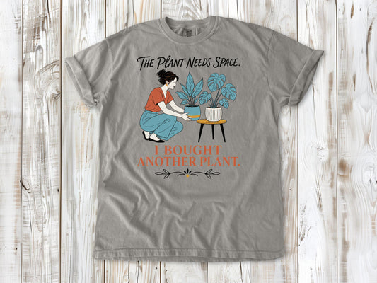 Khaki garment-dyed tee with The Plant Needs Space I Bought Another Plant houseplant graphic.