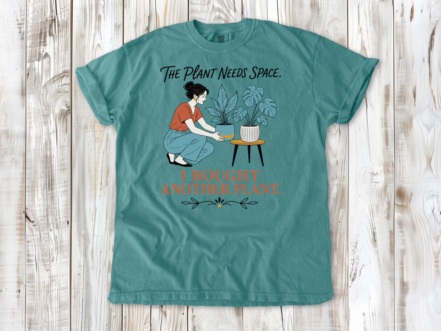 Mustard garment-dyed tee with The Plant Needs Space I Bought Another Plant houseplant graphic.