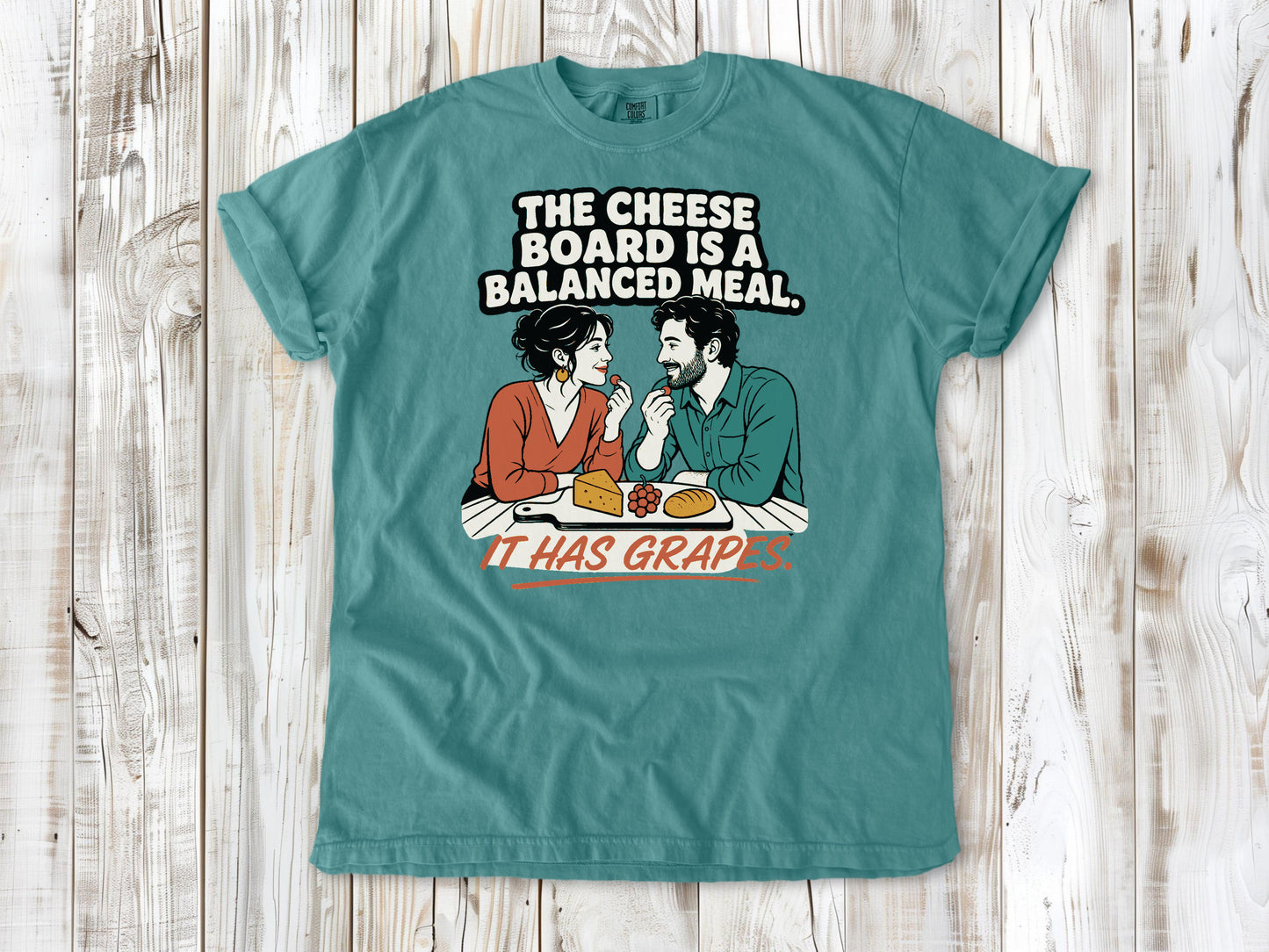 Mustard garment-dyed tee with The Cheese Board Is a Balanced Meal It Has Grapes graphic.