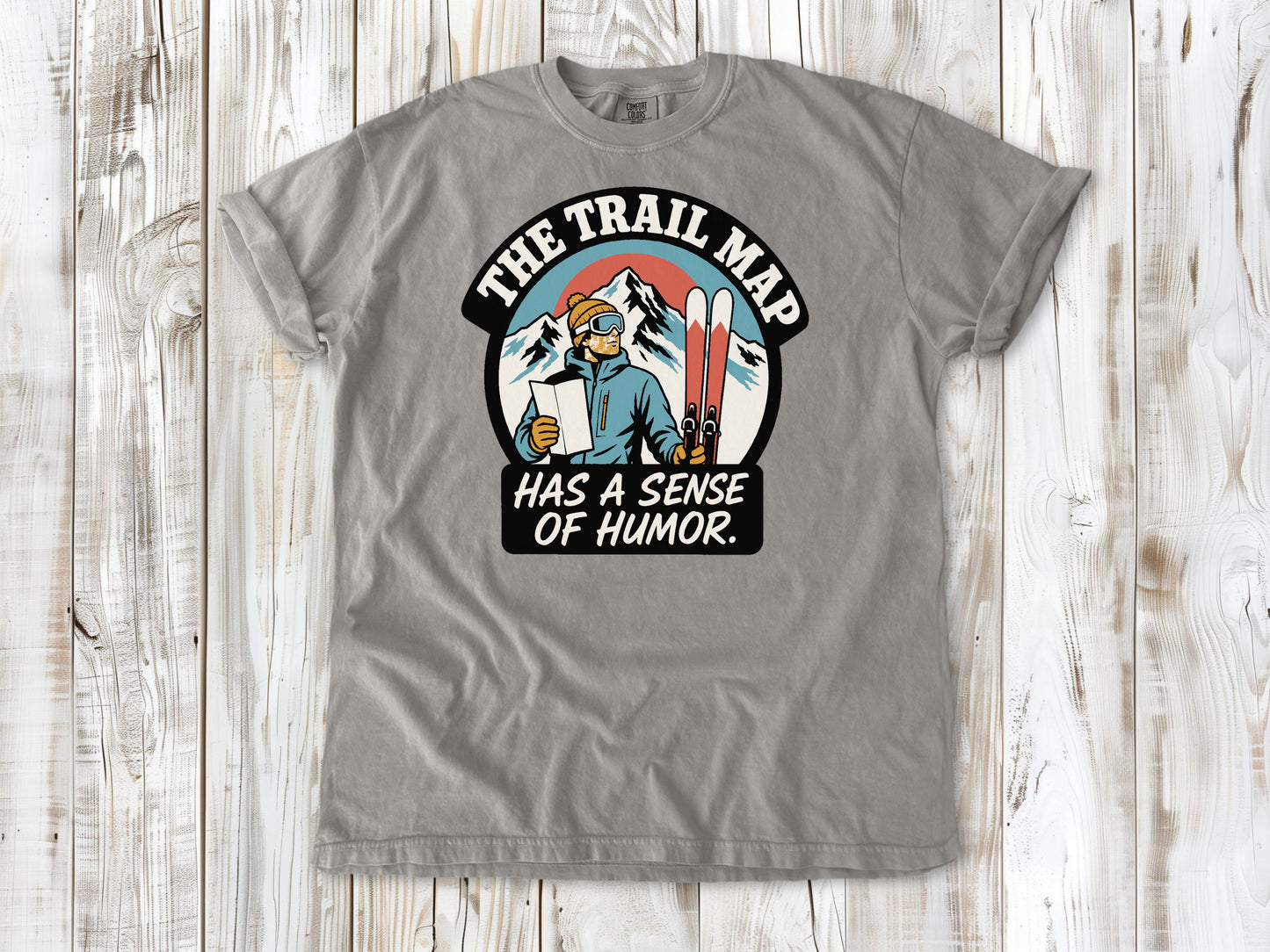 Khaki garment-dyed tee with The Trail Map Has a Sense of Humor hiking graphic.