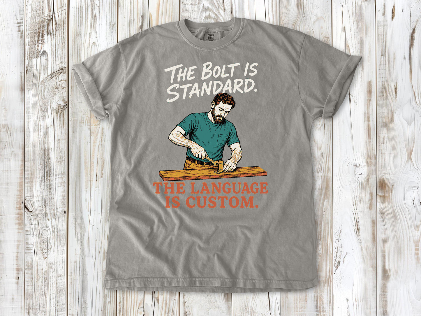 Khaki garment-dyed tee with The Bolt Is Standard The Language Is Custom mechanic graphic.