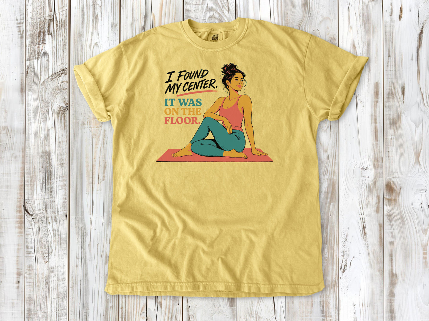 Grey garment-dyed tee with I Found My Center It Was on the Floor yoga graphic.