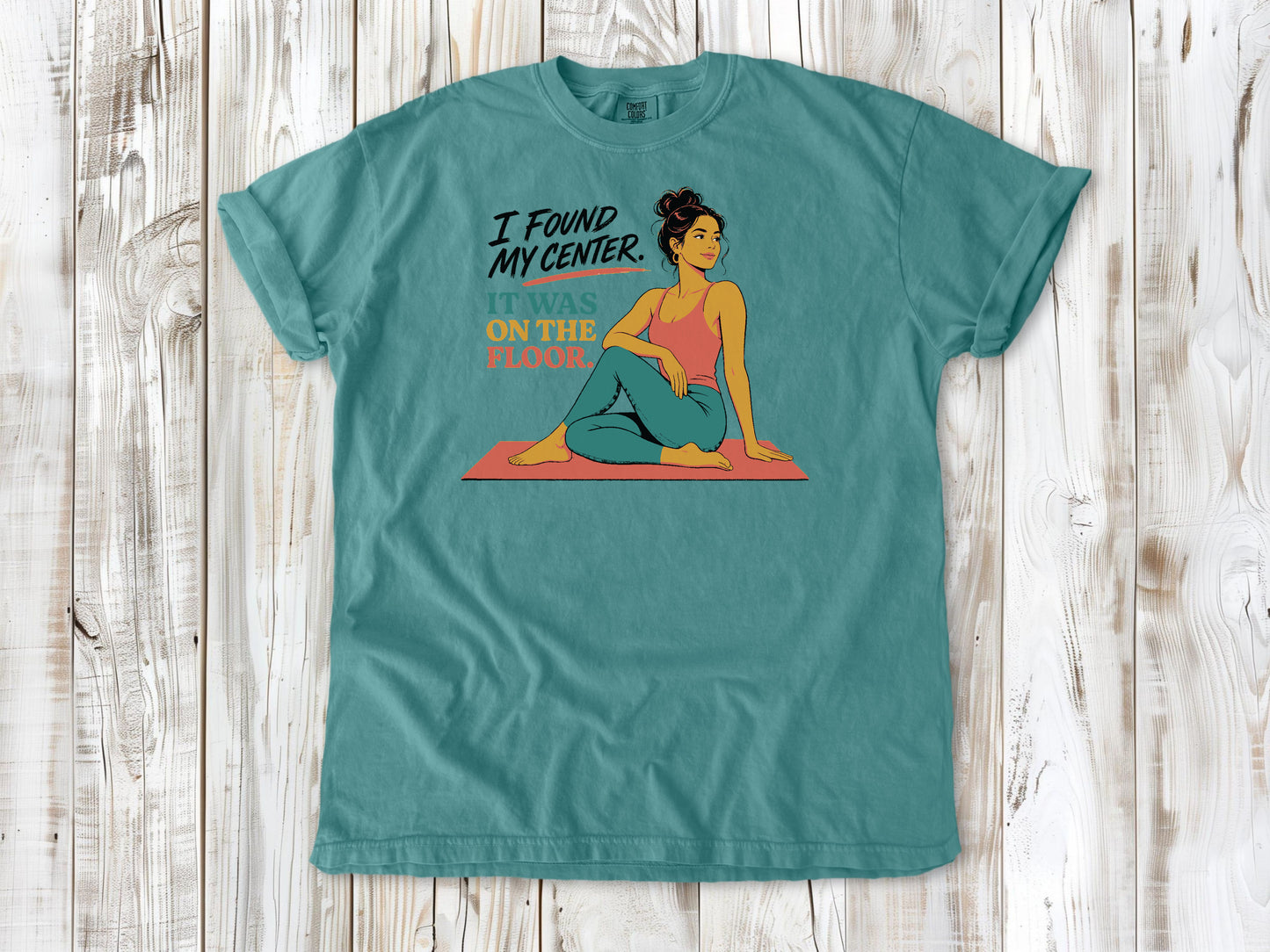 Mustard garment-dyed tee with I Found My Center It Was on the Floor yoga graphic.