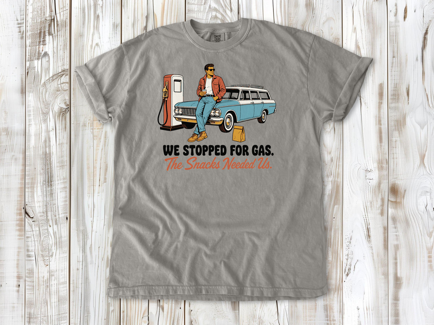 Khaki garment-dyed tee with We Stopped for Gas The Snacks Needed Us road trip graphic.