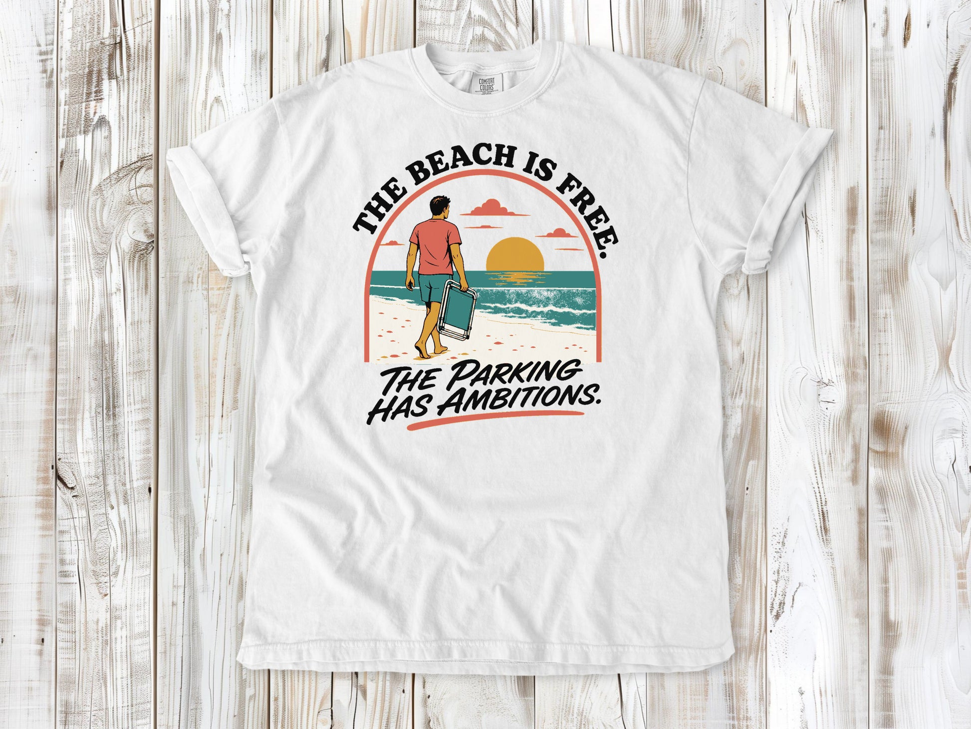 White garment-dyed tee with The Beach Is Free The Parking Has Ambitions coastal graphic.