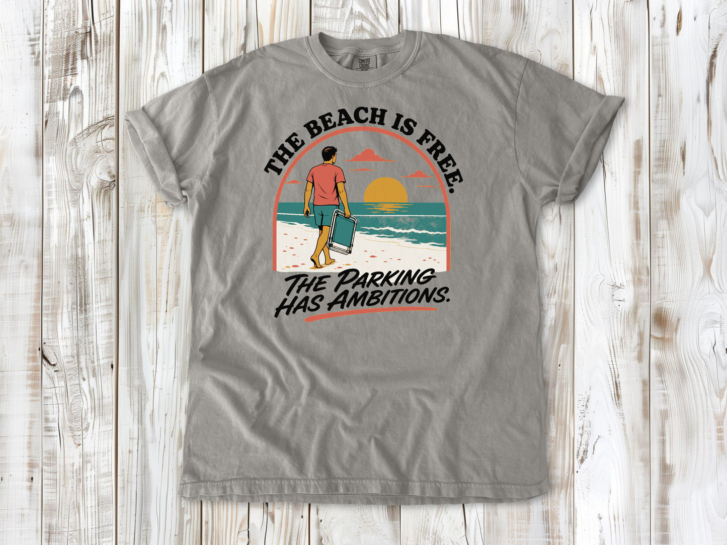Khaki garment-dyed tee with The Beach Is Free The Parking Has Ambitions coastal graphic.
