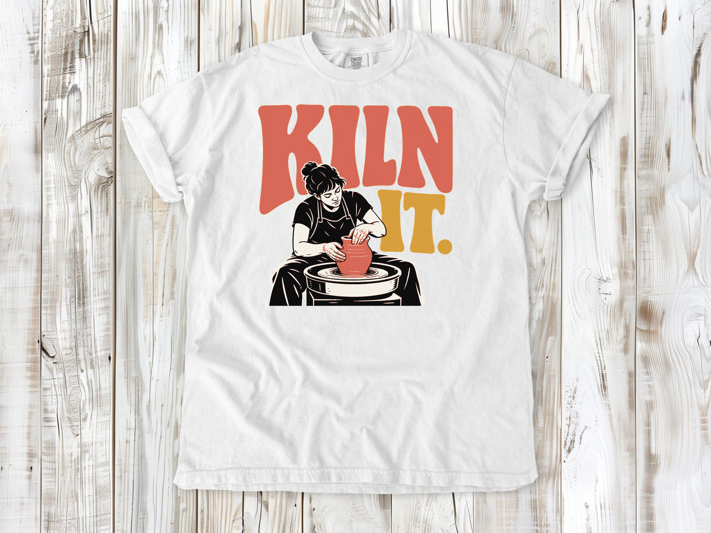 White garment-dyed tee with Kiln It pottery graphic.