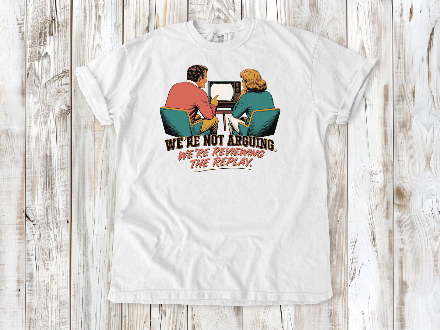 White garment-dyed tee with We're Not Arguing We're Reviewing the Replay game day graphic.