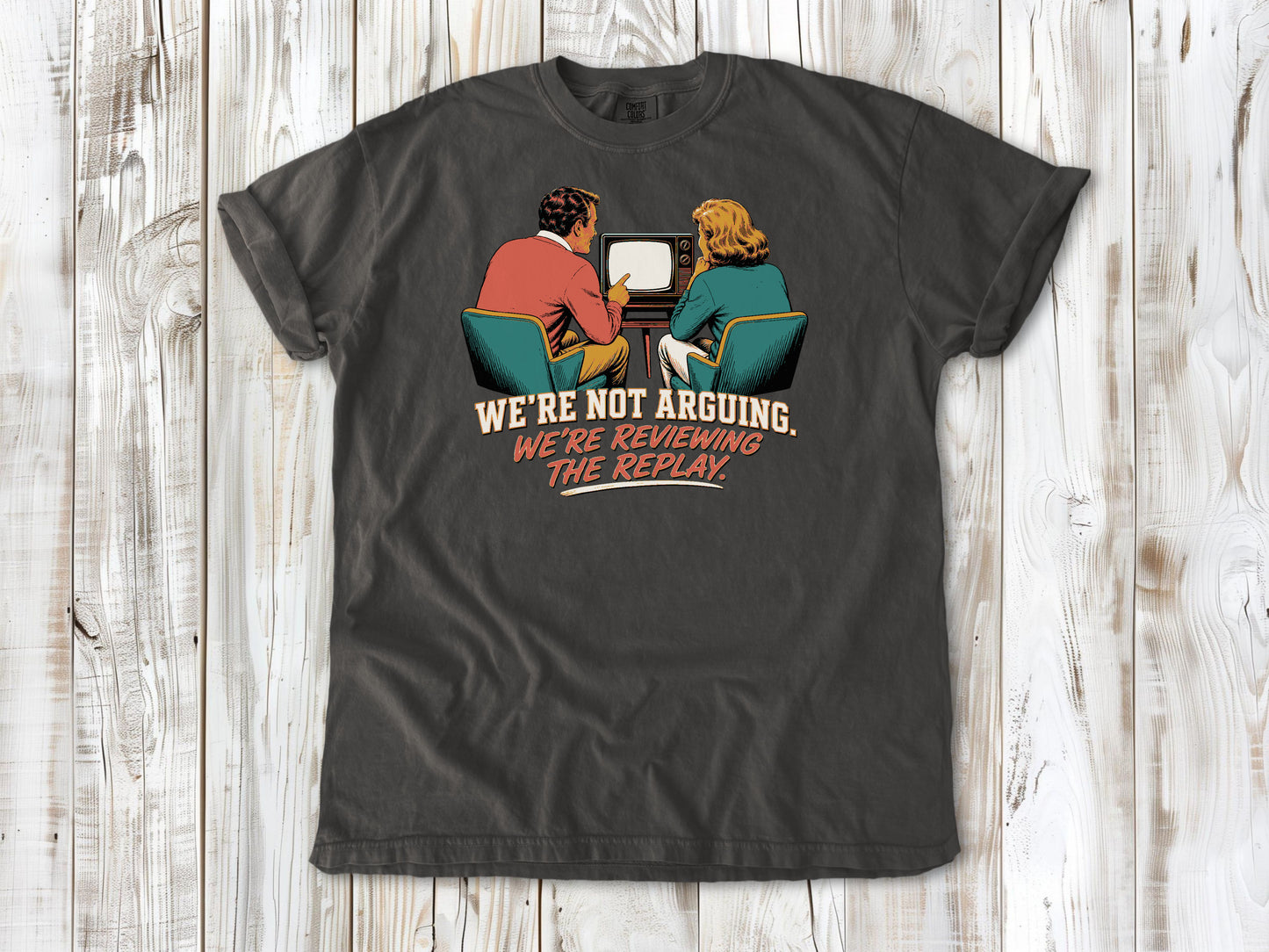 Ivory garment-dyed tee with We're Not Arguing We're Reviewing the Replay game day graphic.