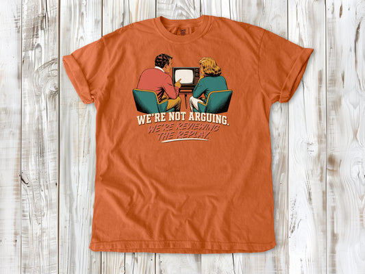 Seafoam garment-dyed tee with We're Not Arguing We're Reviewing the Replay game day graphic.