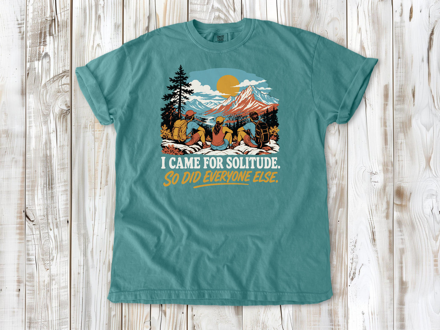Mustard garment-dyed tee with I Came for Solitude So Did Everyone Else hiking graphic.