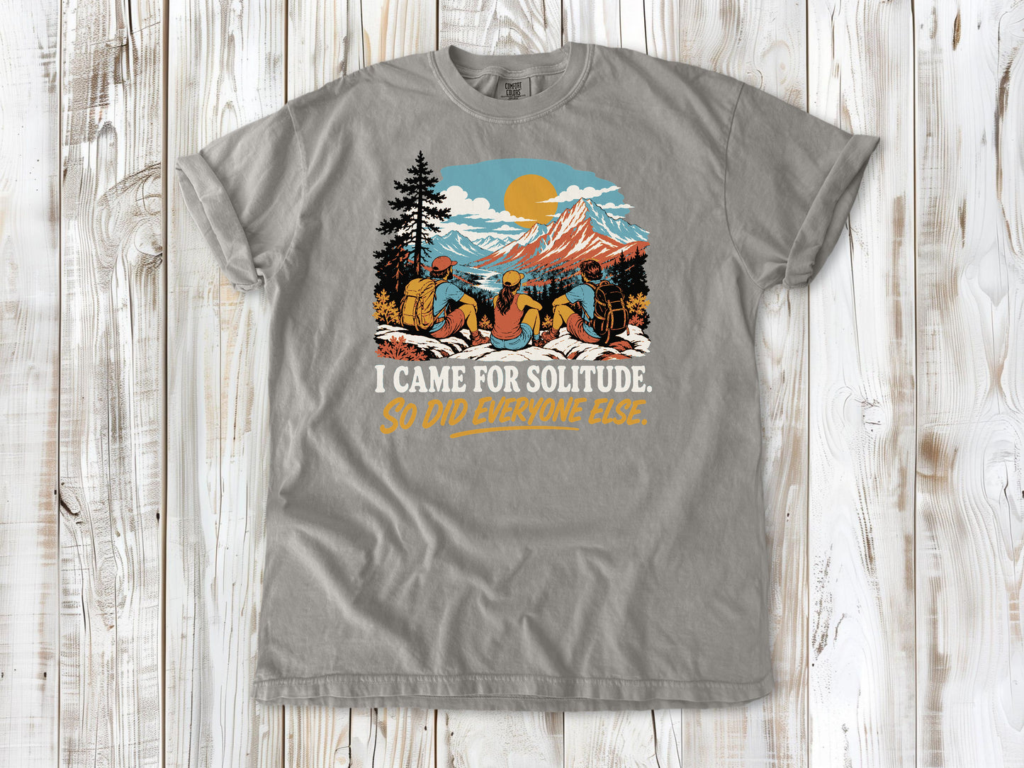 Khaki garment-dyed tee with I Came for Solitude So Did Everyone Else hiking graphic.