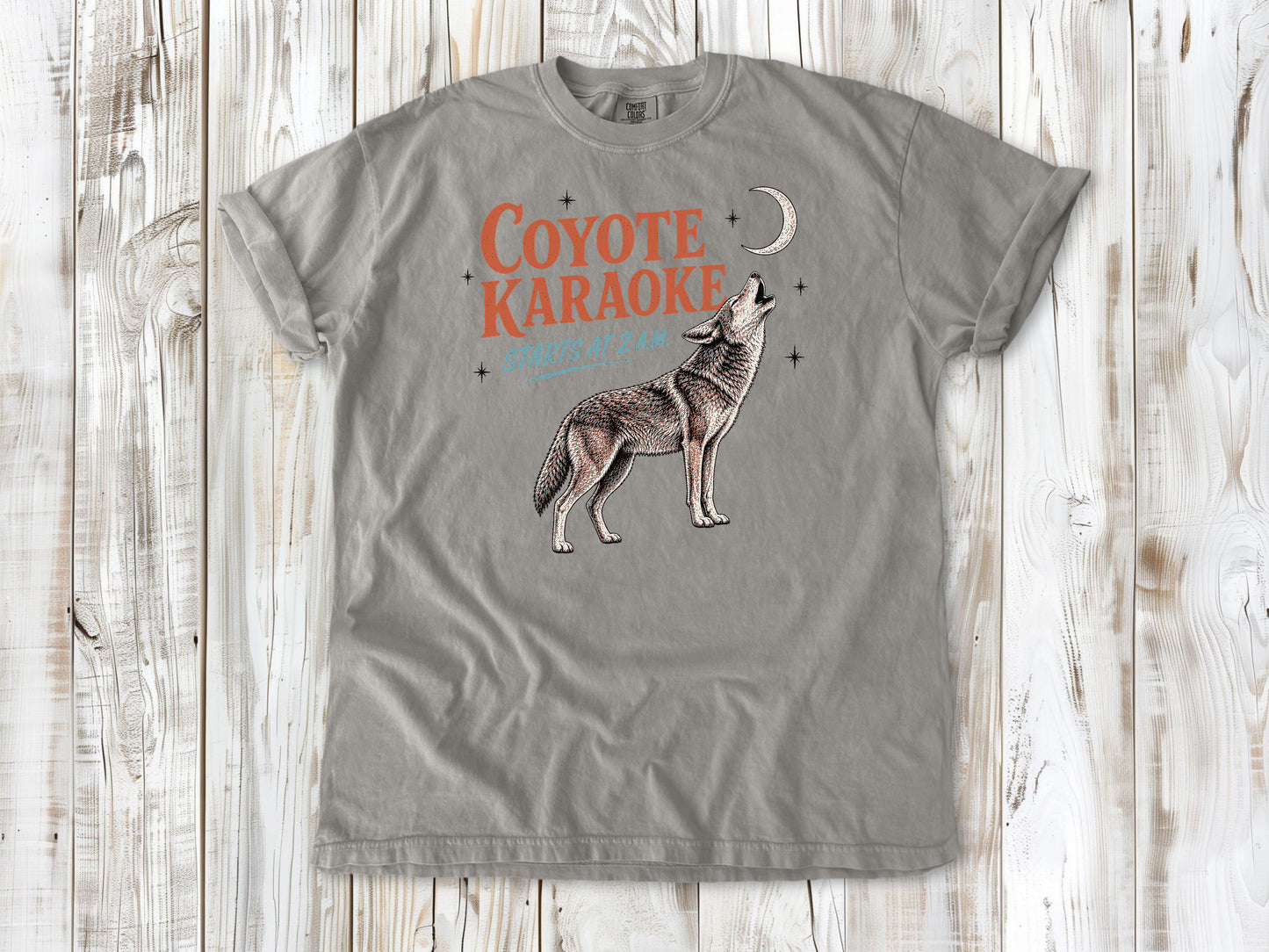Khaki garment-dyed tee with Coyote Karaoke Starts at 2 AM camping graphic.