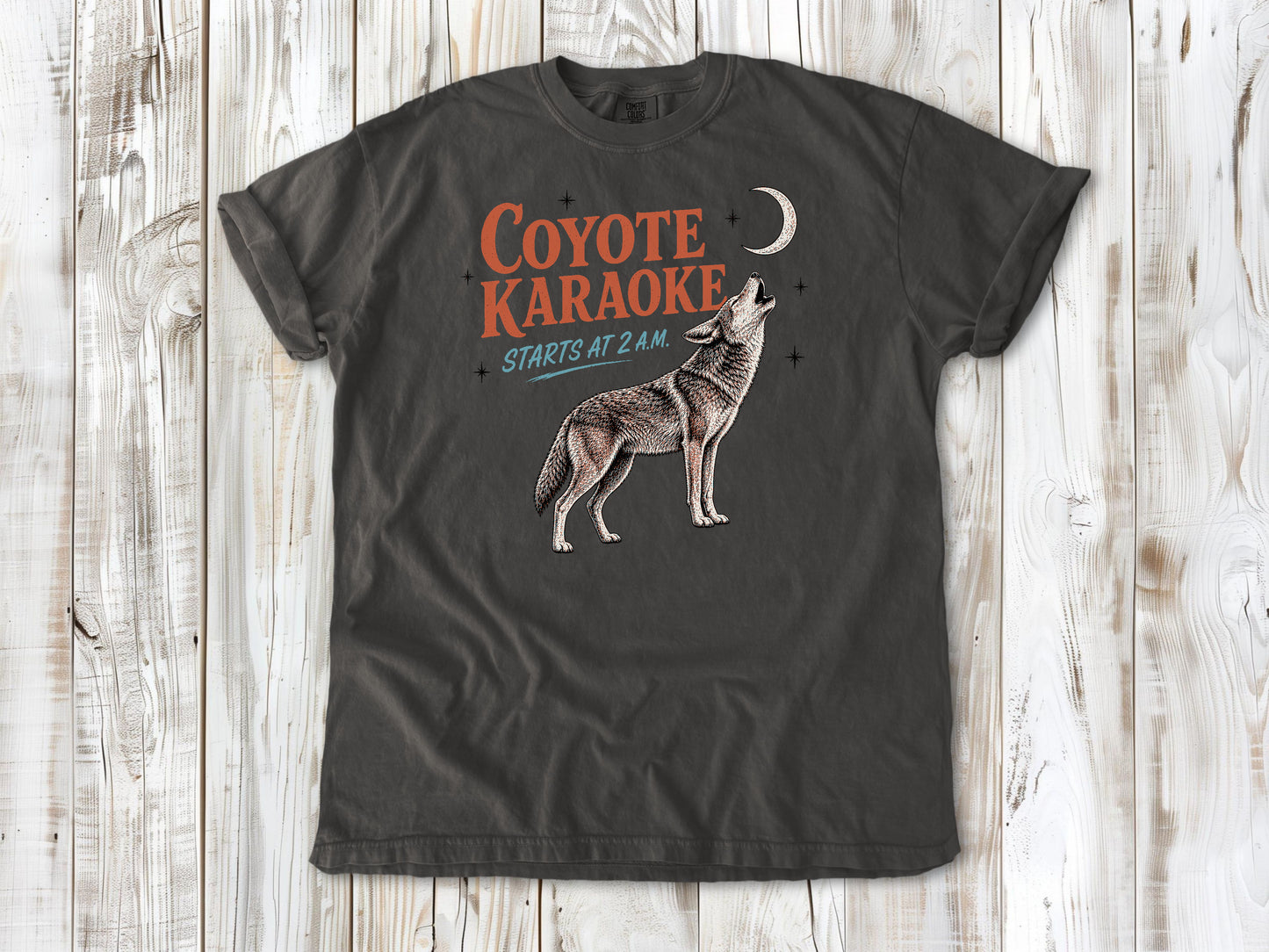 Ivory garment-dyed tee with Coyote Karaoke Starts at 2 AM camping graphic.