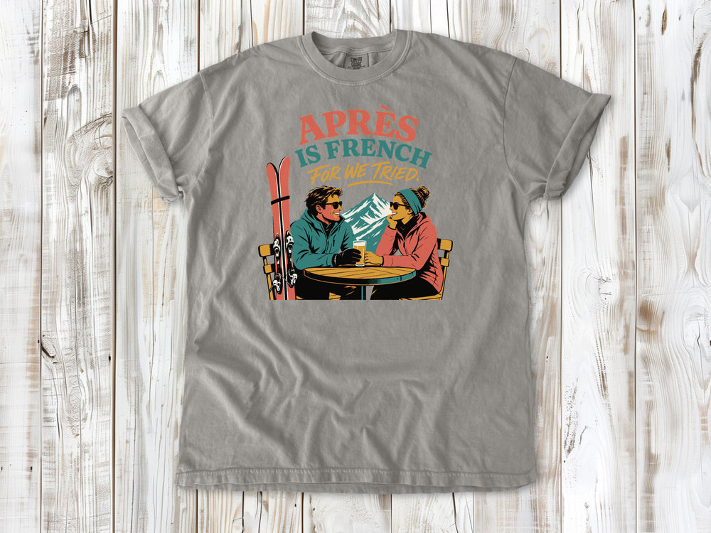 Khaki garment-dyed tee with Après Is French for We Tried skiing graphic.