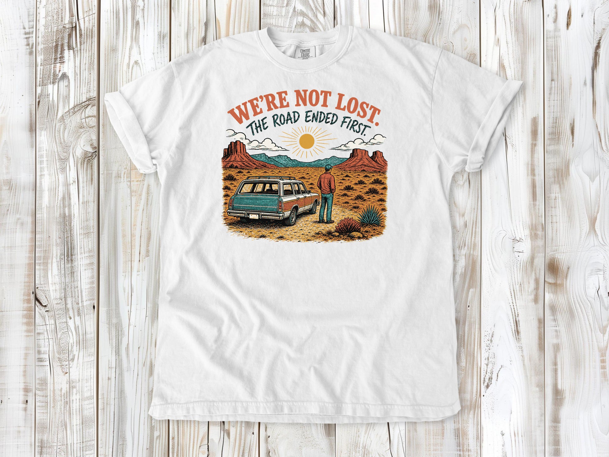 White garment-dyed tee with We're Not Lost The Road Ended First off-road graphic.