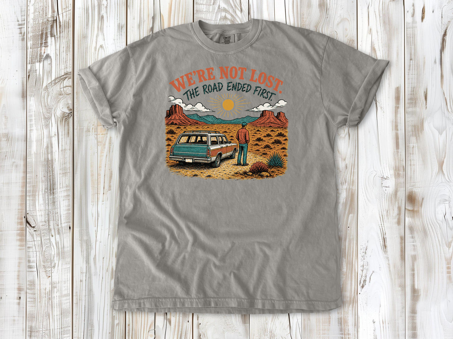 Khaki garment-dyed tee with We're Not Lost The Road Ended First off-road graphic.