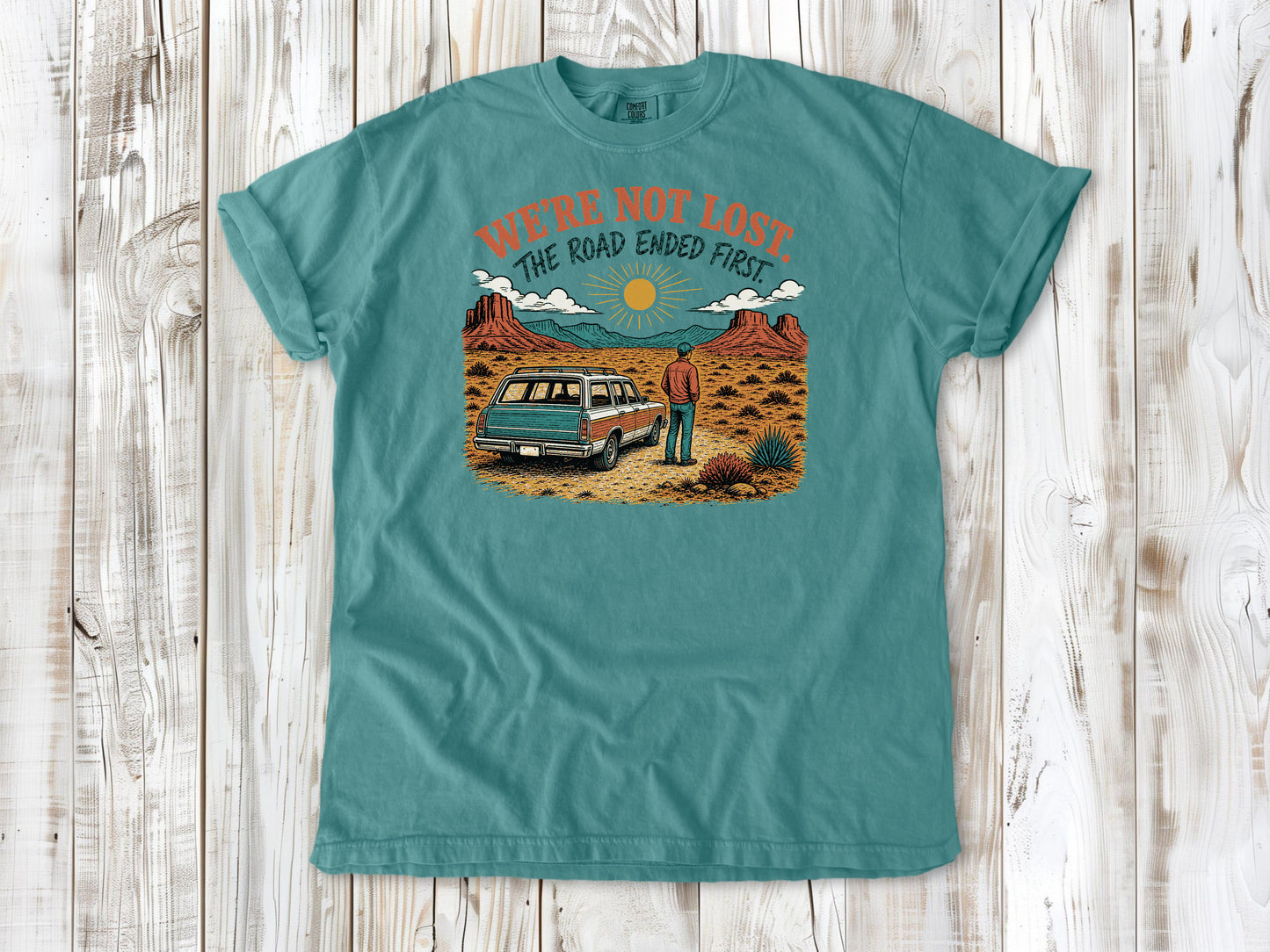 Mustard garment-dyed tee with We're Not Lost The Road Ended First off-road graphic.