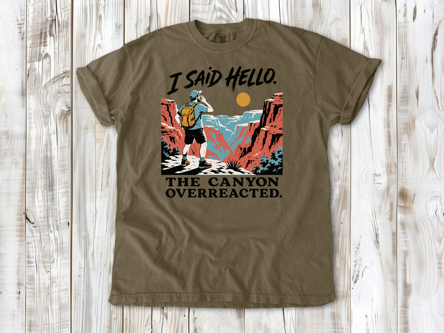 Graphite garment-dyed tee with I Said Hello The Canyon Overreacted hiking graphic.