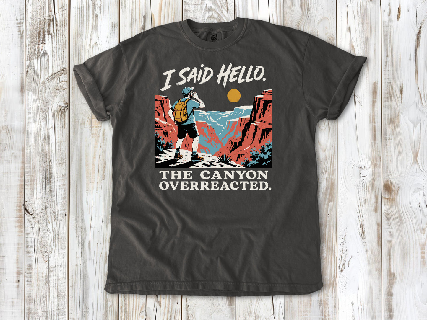 Ivory garment-dyed tee with I Said Hello The Canyon Overreacted hiking graphic.