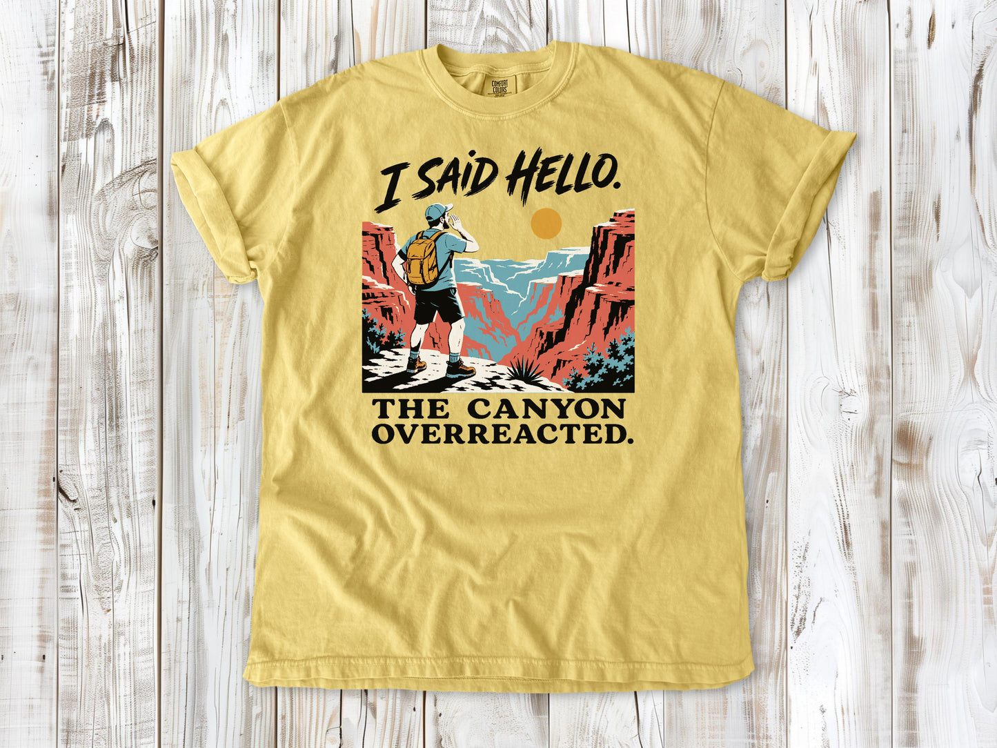Grey garment-dyed tee with I Said Hello The Canyon Overreacted hiking graphic.