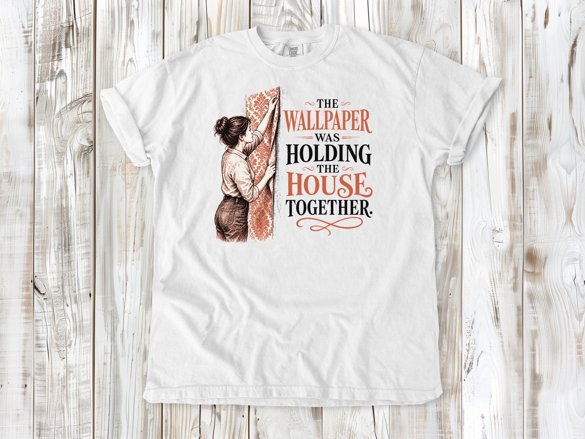 White garment-dyed tee with The Wallpaper Was Holding the House Together renovation graphic.