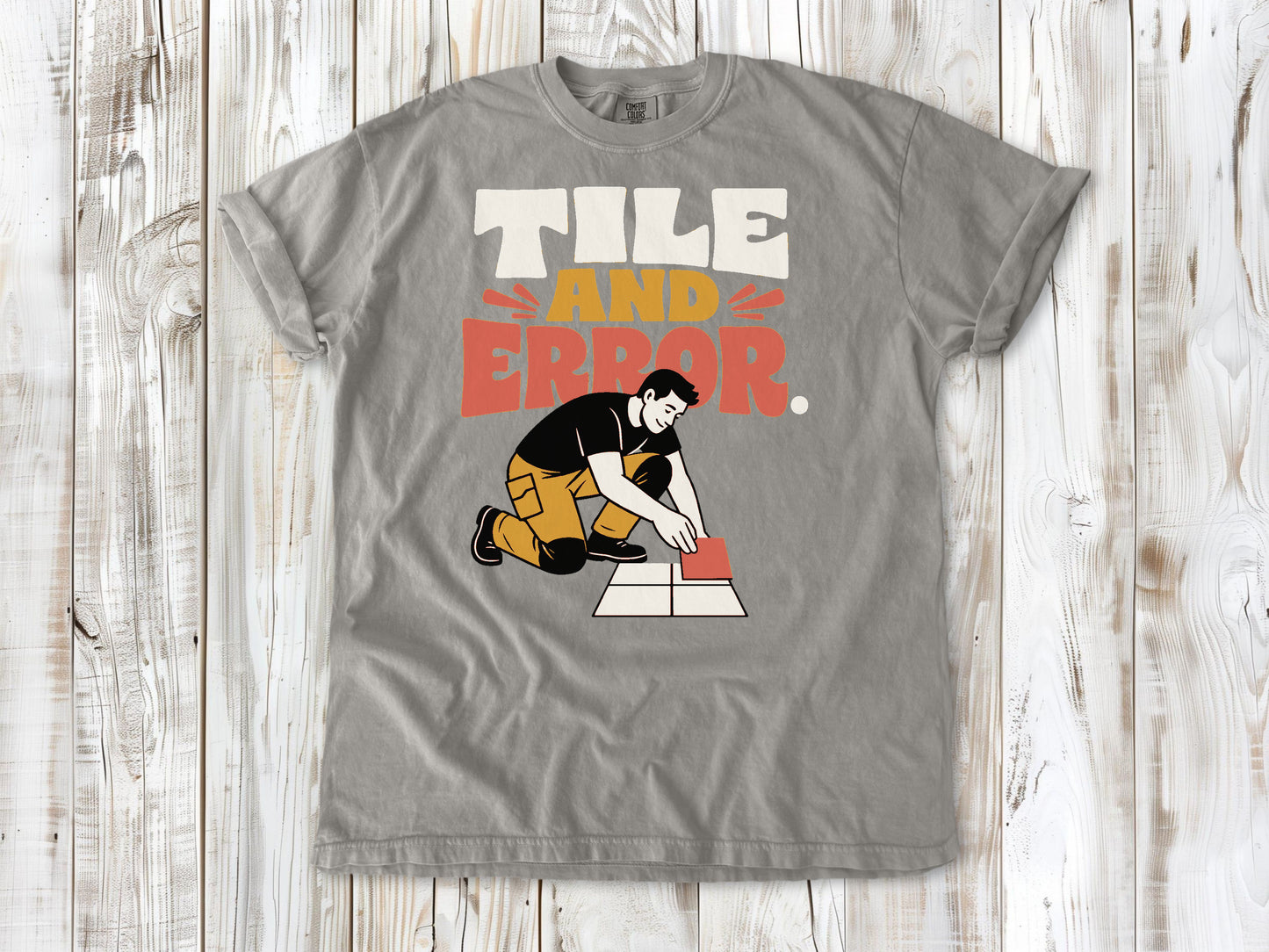 Khaki garment-dyed tee with Tile and Error tile setter graphic.
