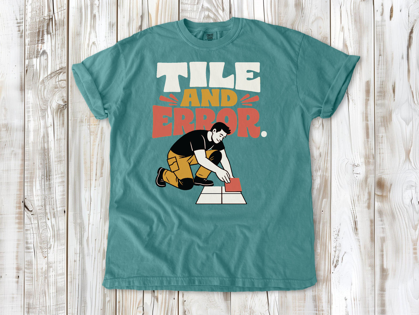 Mustard garment-dyed tee with Tile and Error tile setter graphic.