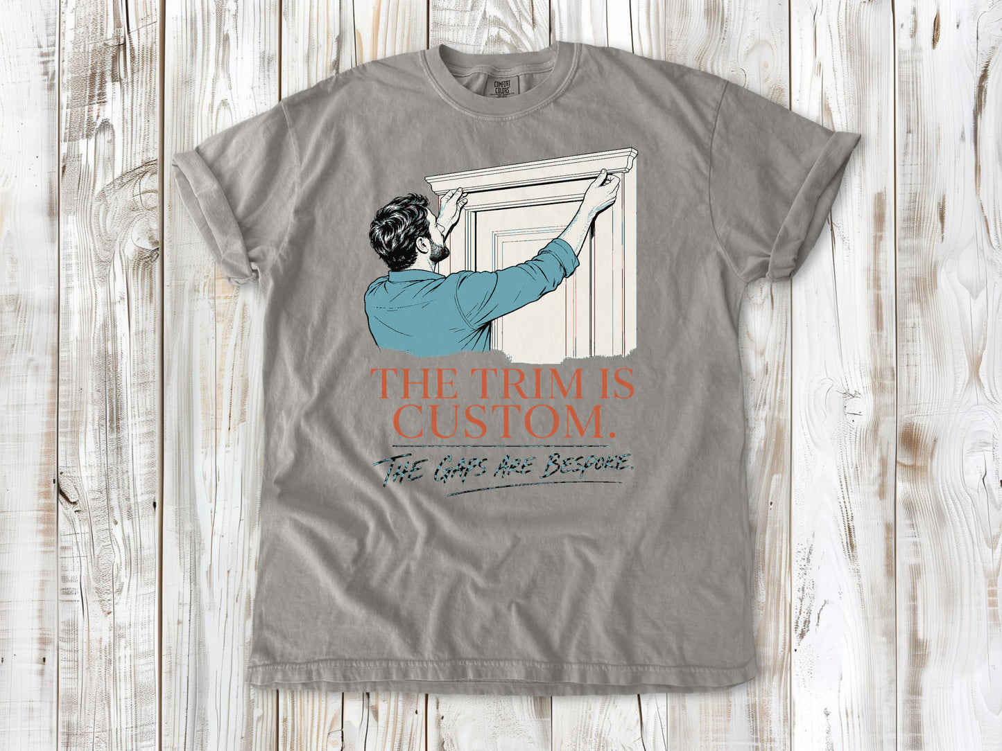 Khaki garment-dyed tee with The Trim Is Custom The Gaps Are Bespoke finish carpentry graphic.