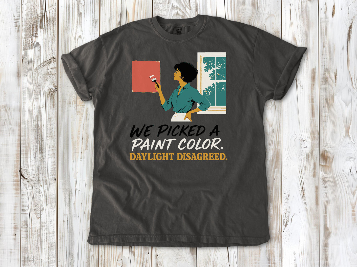 Ivory garment-dyed tee with We Picked a Paint Color Daylight Disagreed painting graphic.