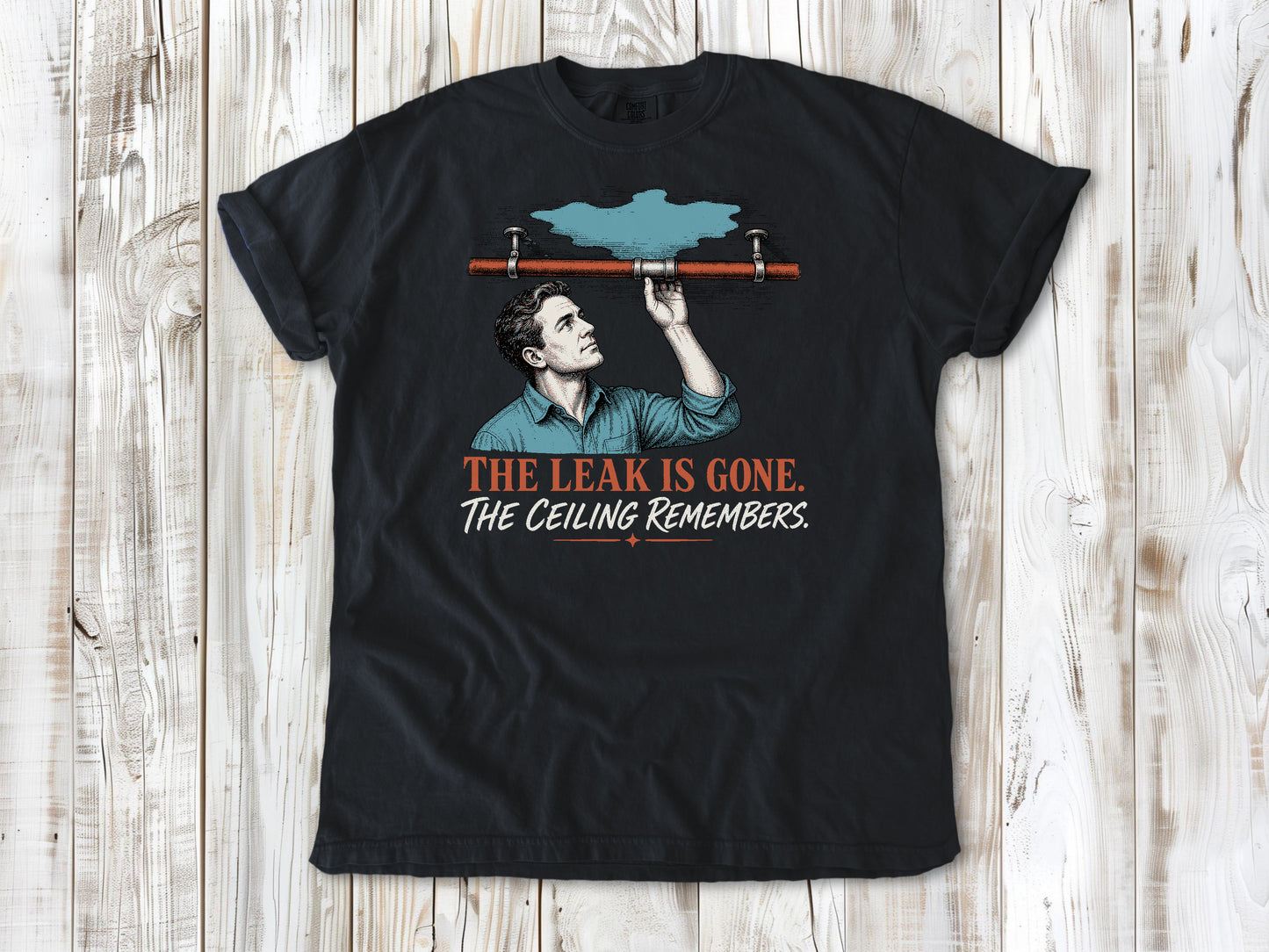 Washed Denim garment-dyed tee with The Leak Is Gone The Ceiling Remembers home repair graphic.