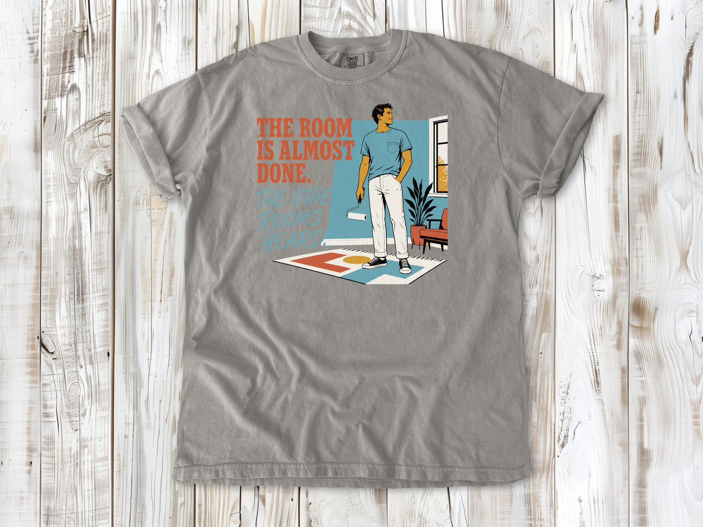 Khaki garment-dyed tee with The Room Is Almost Done The Other Rooms Heard renovation graphic.