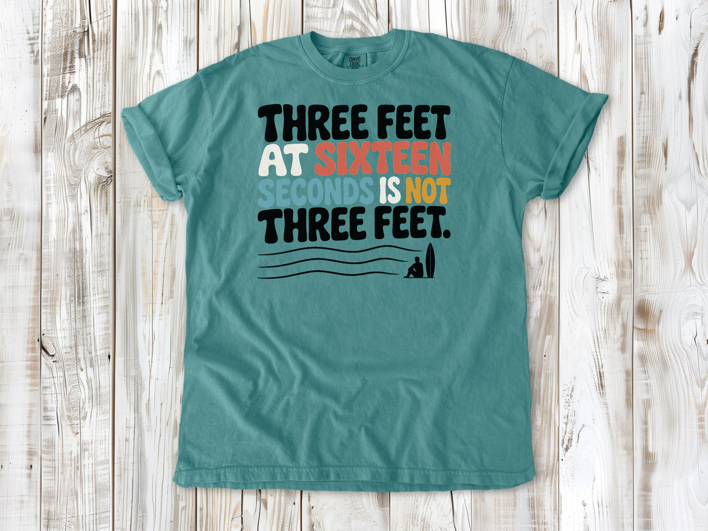 Mustard garment-dyed tee with Three Feet at Sixteen Seconds Is Not Three Feet surf forecast graphic.