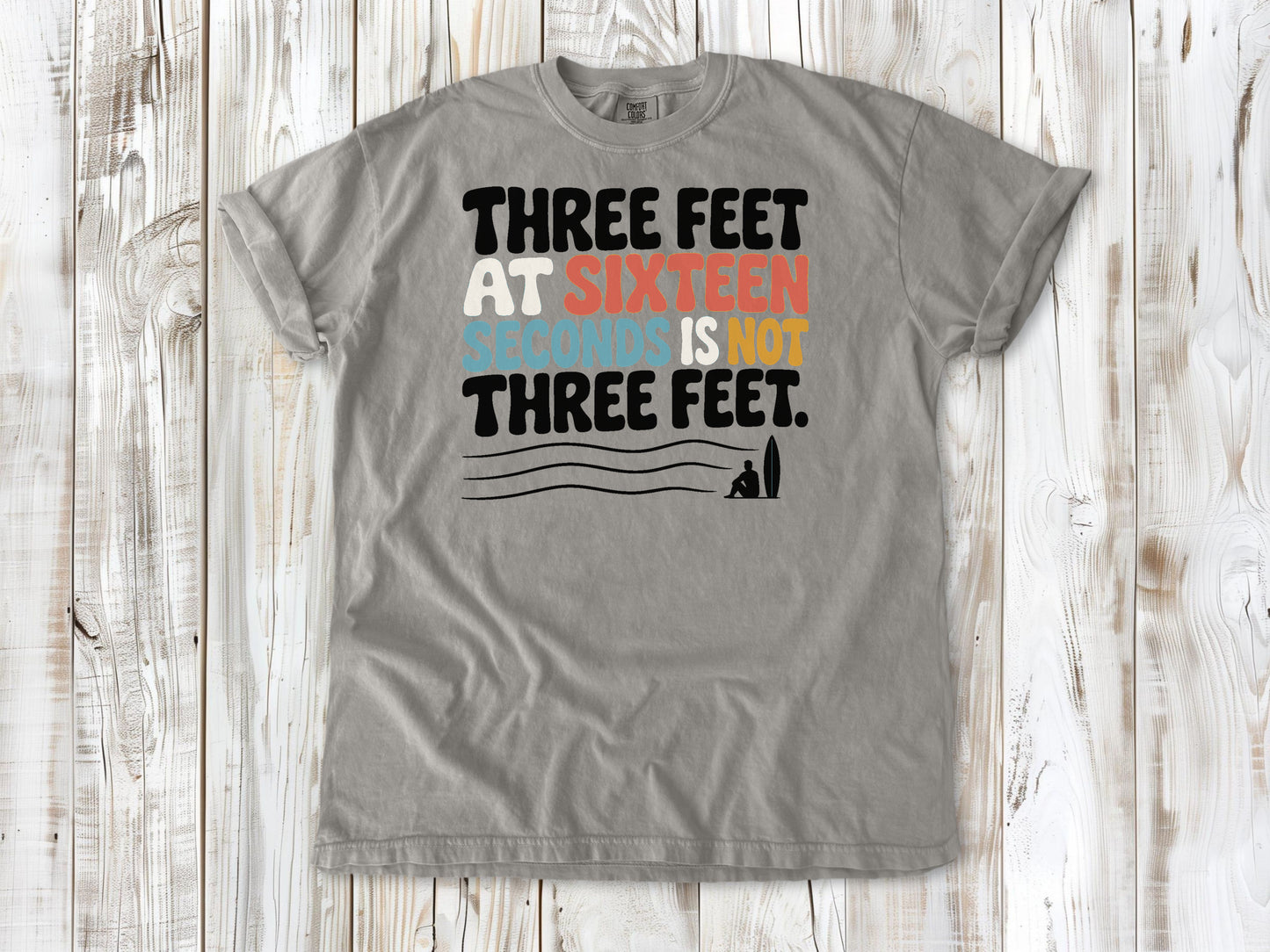 Khaki garment-dyed tee with Three Feet at Sixteen Seconds Is Not Three Feet surf forecast graphic.